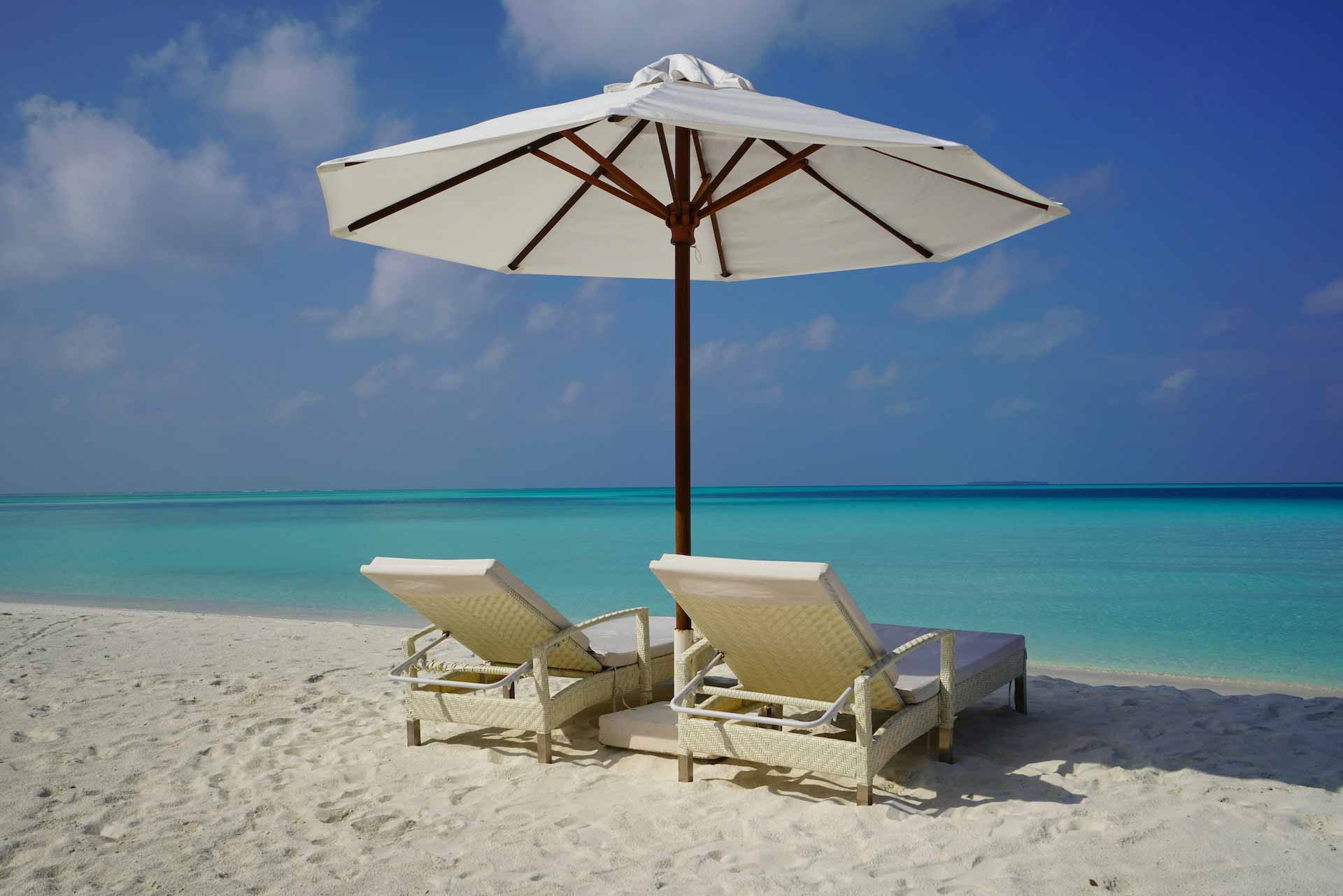 Two chairs under an umbrella on a beach