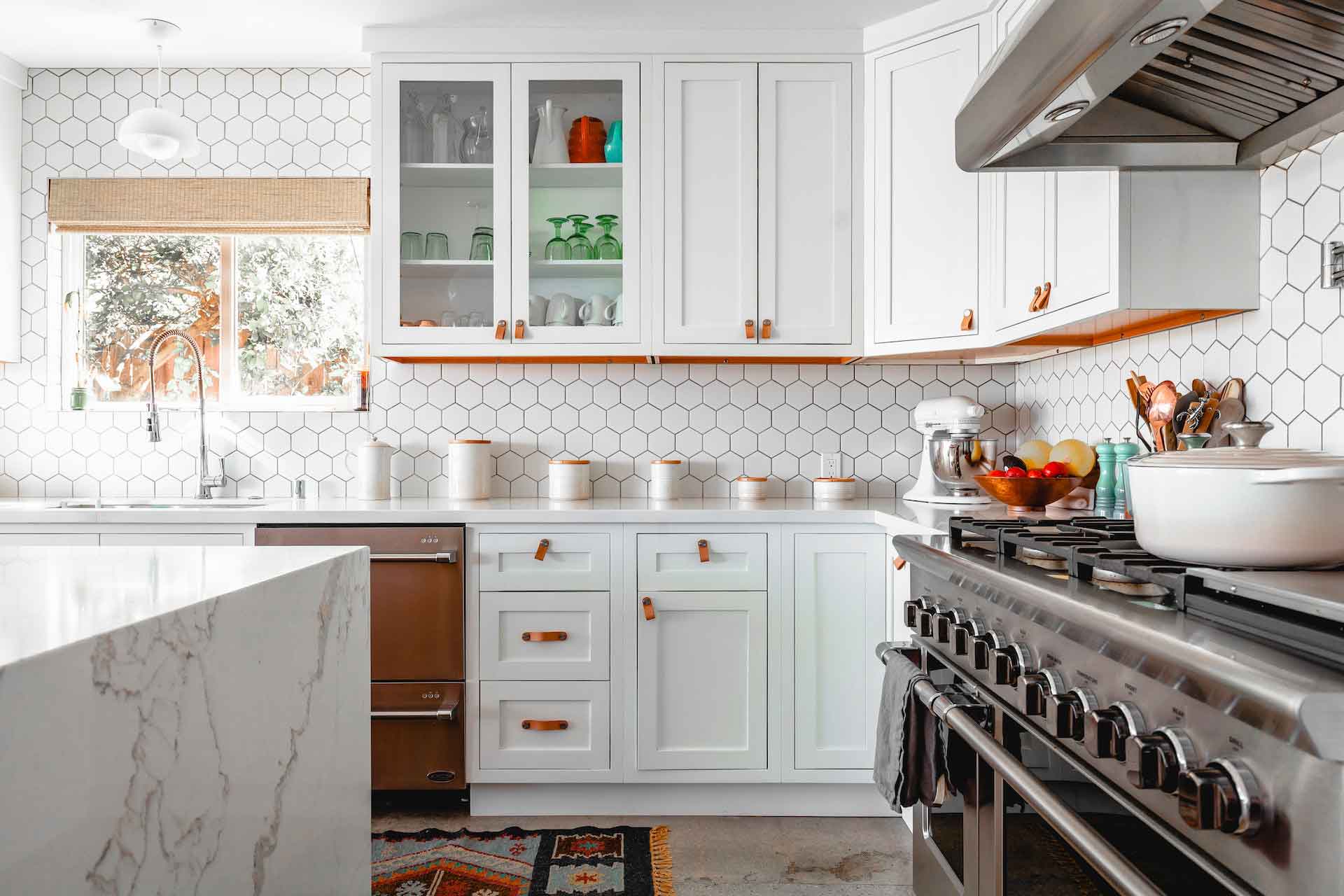 Clean kitchen with granite countertops and hexagonal tile backsplash